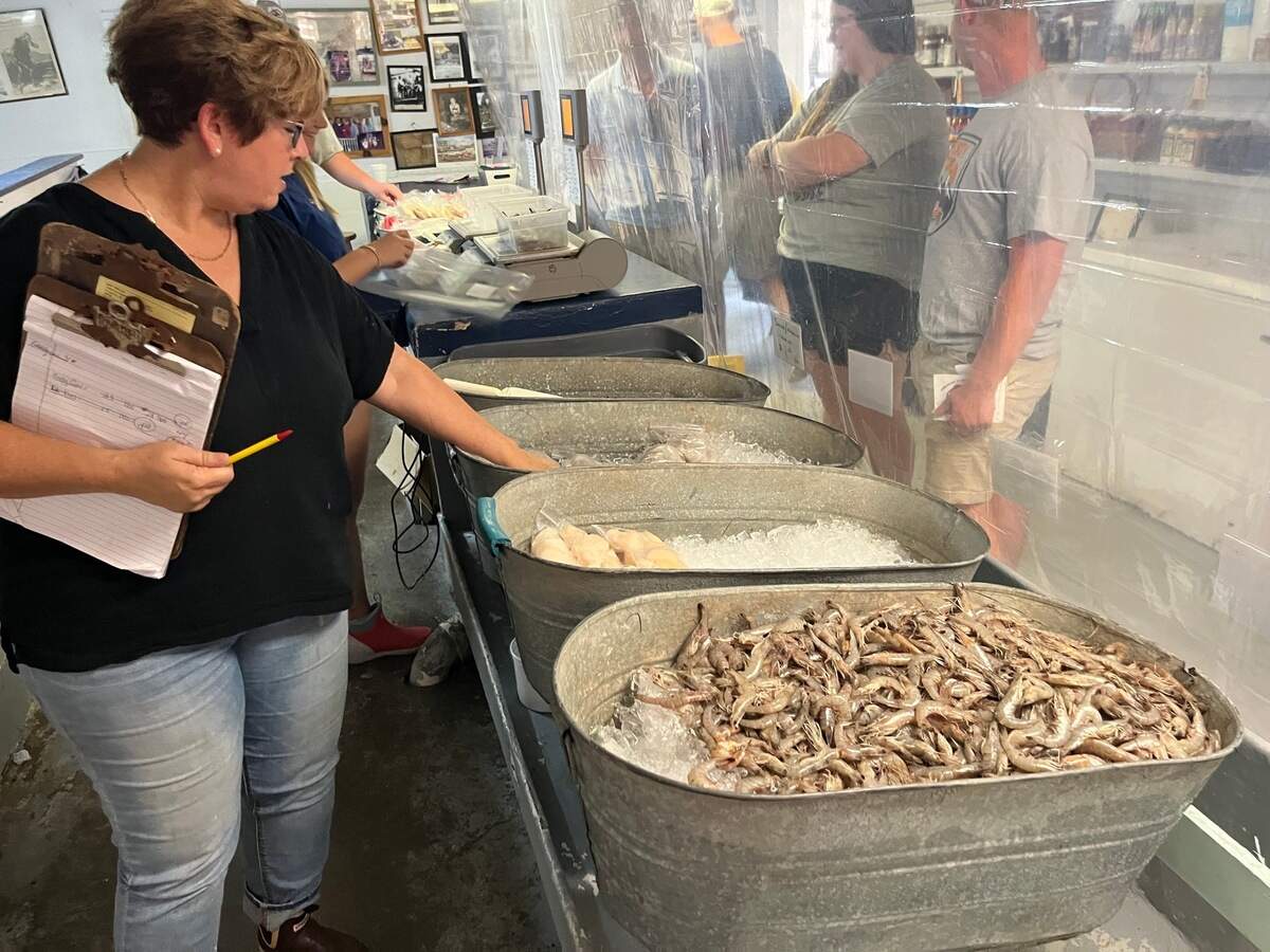 In this 2023 file photo, Cyndy Carr checks the display counter at Gay Fish Co. on St. Helena Island which includes fresh seafood including locally-caught shrimp delivered to its docks on Ward Creek, located directly behind the retail store.