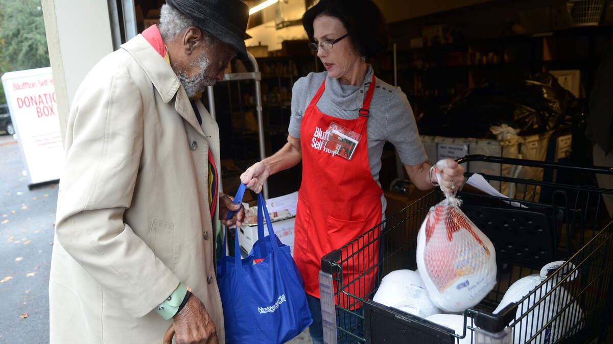 Donna Della Rosa, right, a volunteer with Bluffton Self Help, hands a bag of canned goods and a frozen turkey to George Moorman of Bluffton on Tuesday afternoon at their distributing center in Bluffton.