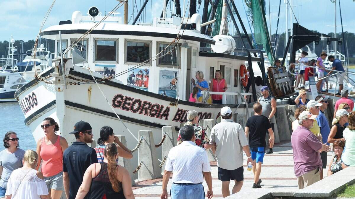 Festival goers walk past the shrimp boat Georgia Bulldog which was offering free tours during the 2017 Beaufort Shrimp Festival on at Henry C. Chambers Waterfront Park. The festival is one of the sticking points in an ongoing dispute between the city and Beaufort Regional Chamber of Commerce.
