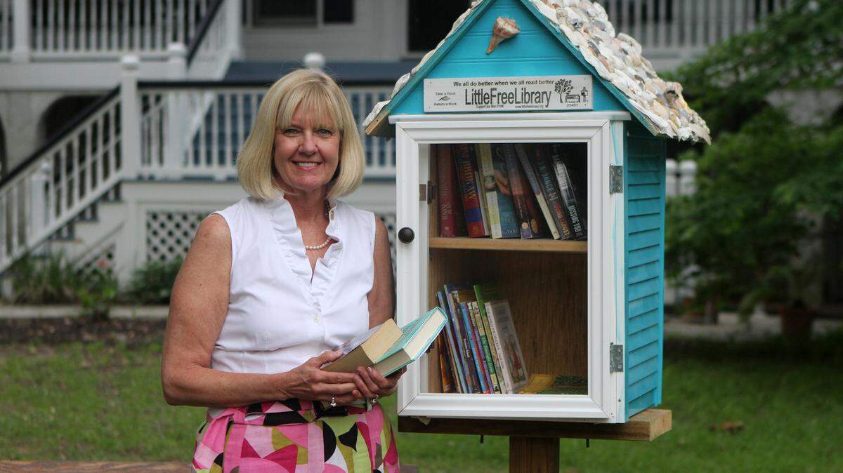 Terri Stokes of Beaufort stands with her Little Library outside of her home on Tuesday afternoon in Beaufort.  Her husband, Mark Stokes, built the box for her as a Mother's Day gift this year.
