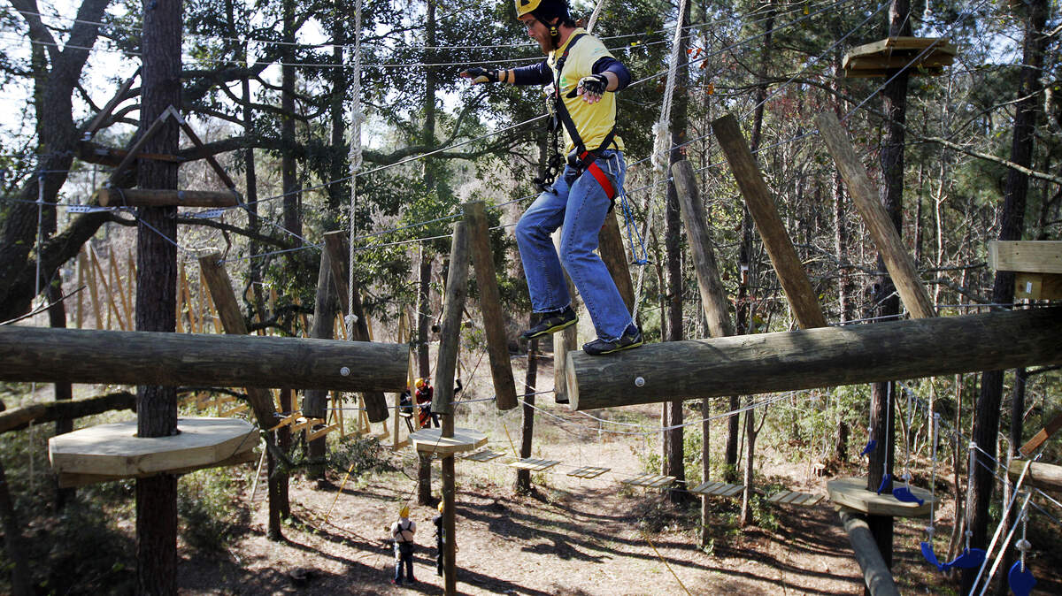 Tour guide Nathan Addy, 29, balances on a three-story high beam during an inspection the morning of March 26, 2014, of the new aerial adventure at Zipline Hilton Head.