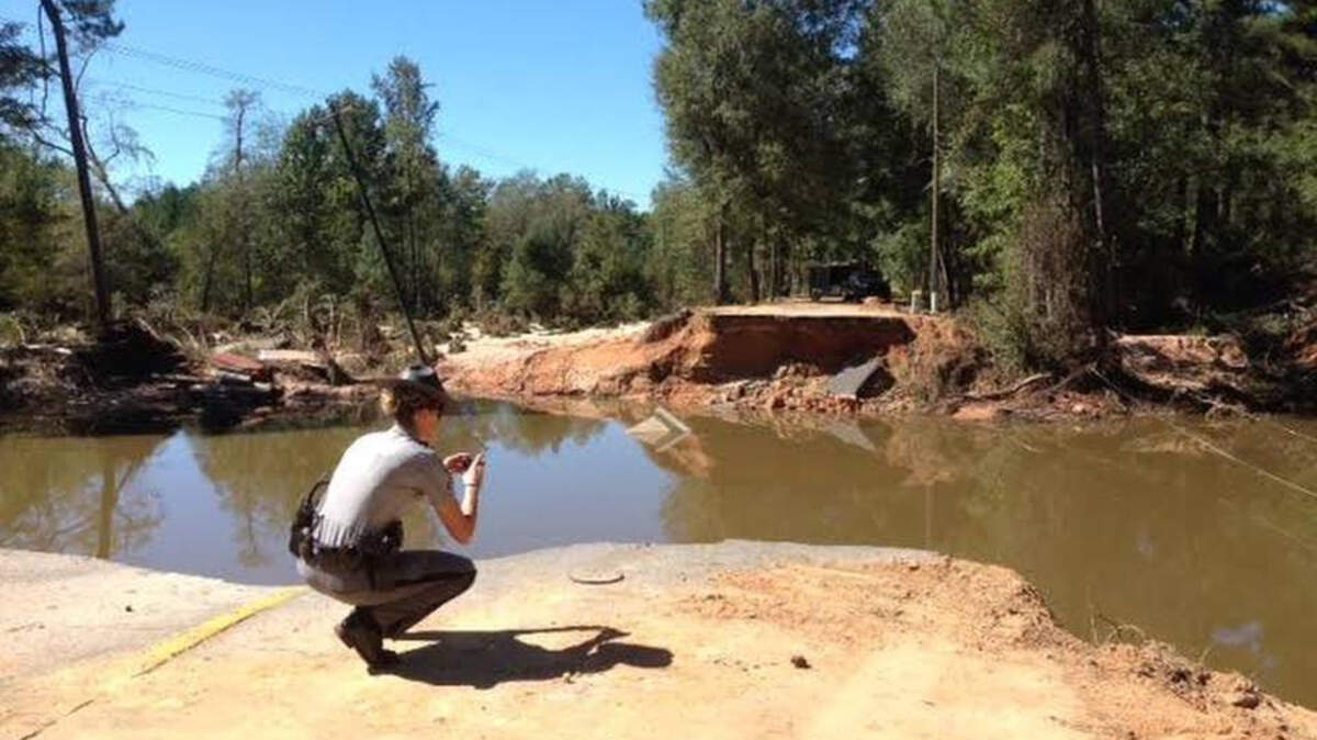 A S.C. Highway Patrol trooper inspects the crash site where two bodies were pulled from the water the afternoon of Oct. 7, 2015, after an truck carrying five railroad contractors ran through a barricade and fell into the water earlier that morning.