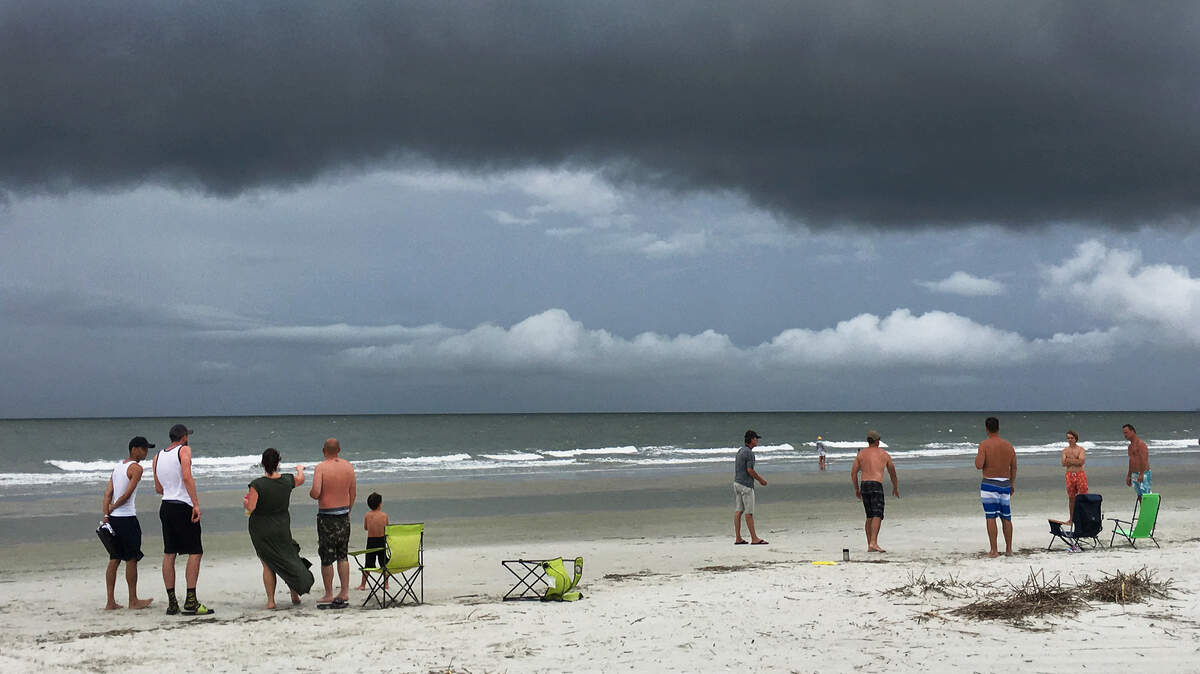 Beachgoers keep an eye on the sky as rain clouds approach Hilton Head Island’s South Forest Beach on an afternoon in August, 2018.