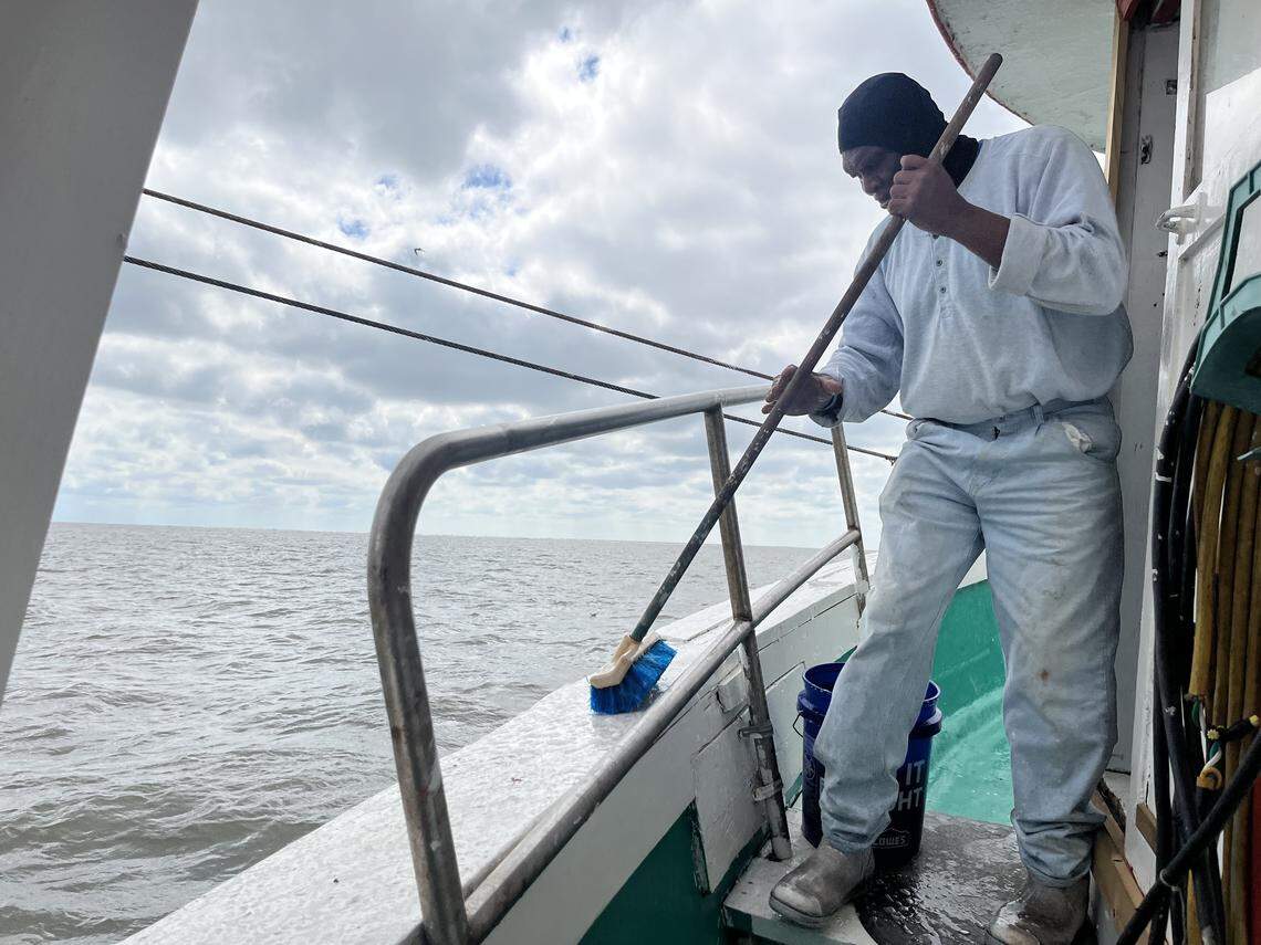 Arthur Duncan cleans the deck while the Gracie Bell trawls for shrimp in St. Helena Sound.