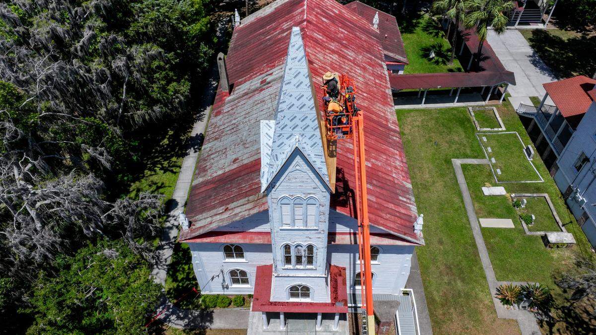 This drone photo shows R.J. Arnold, top, and Ervin “Catman” Golden with Savannah-based Metalcrafts, a Tecta America Company, work on April 30, 2025, to repair the 65-foot steeple of the Tabernacle Baptist Church in Historic Downtown Beaufort.