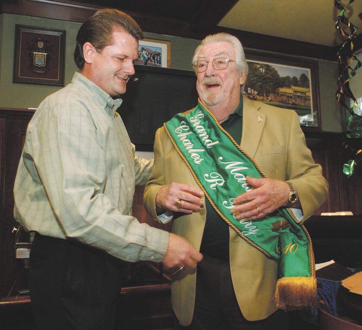 2/23/10 Jay Karr/The Island Packet Long-time islander Charles Perry, right, was named grand marshal of the 2010 Hilton Head Island St. Patrick’s Day Parade during a ceremony on Wednesday at Reilley’s restaurant on the south end. Placing the grand marshal sash on Perry was his son, Alan Perry, who is a member of the parade committee. The 27th edition of the parade down Pope Avenue will kick off at 3 p.m. on Sunday, March 14.
