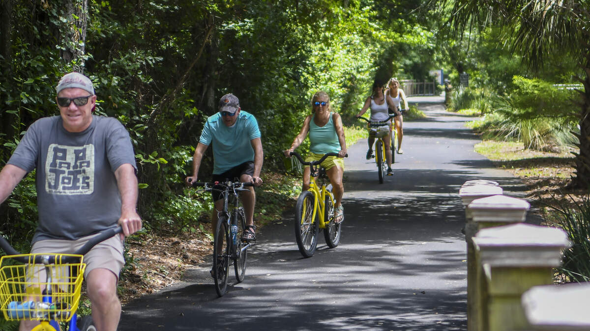 A group of cyclists pedal their way down a bike path along Pope Avenue on Friday, May 15, 2020 on Hilton Head Island, calling out “We’re from Ohio.” when asked whether they were visiting.