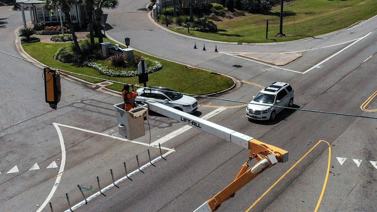 A worker with W.M. Roebuck Inc. installs a traffic signal at the intersection of U.S. 278 at Windmill Harbour on Wednesday, Sept. 13, 2023, on Jenkins Island. According to a Beaufort County notice posted on Sept. 8, the installation is expected to be finished in three weeks. The temporary wood poles will be replaced with mast arms and signaling software the Town of Hilton Head Island is currently using when the US 278 Corridor Project gets underway.