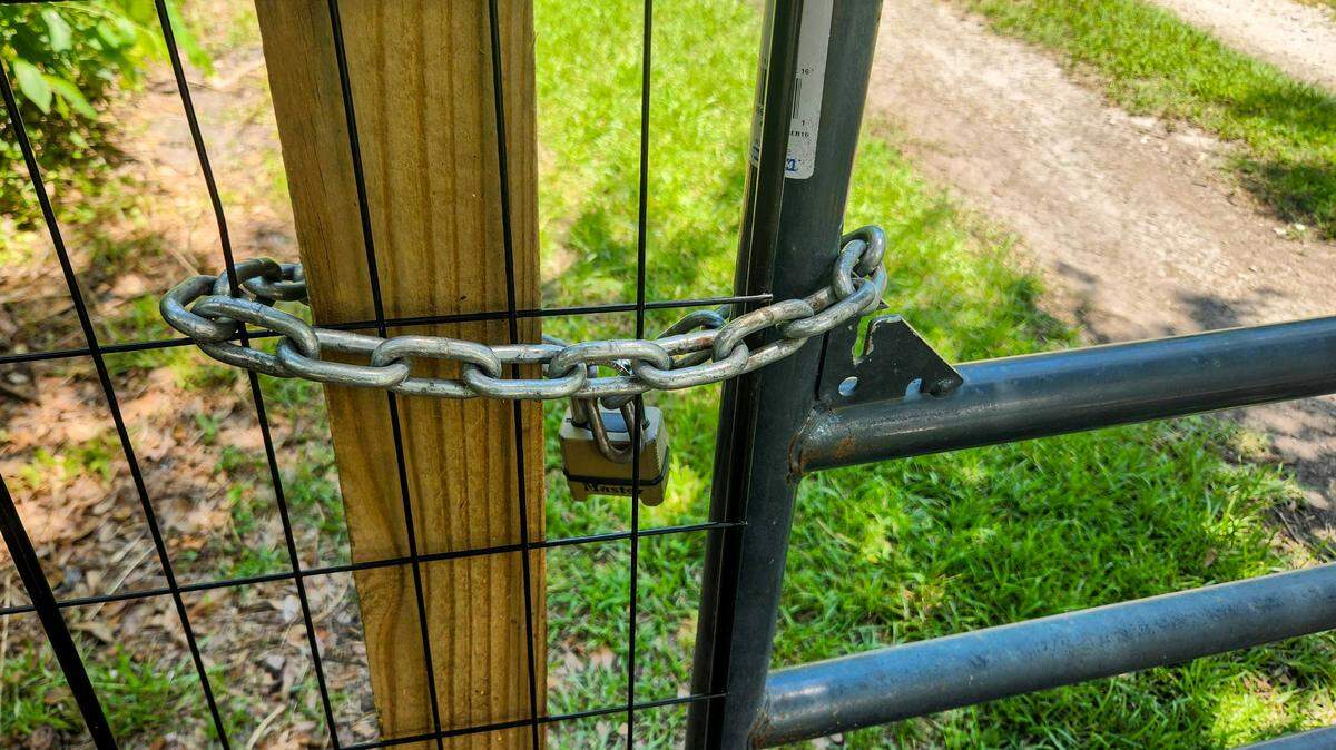 The locked gate at Terri Aigner’s property and neighbors as photographed on Wednesday, July 10, 2024 at the end of Everest Road on St. Helena Island. Aigner, who maintains that the road is private, placed the gate after numerous vehicles and large trucks used by funeral homes, damaged the road after a heavy rainfall, leaving it impassable.