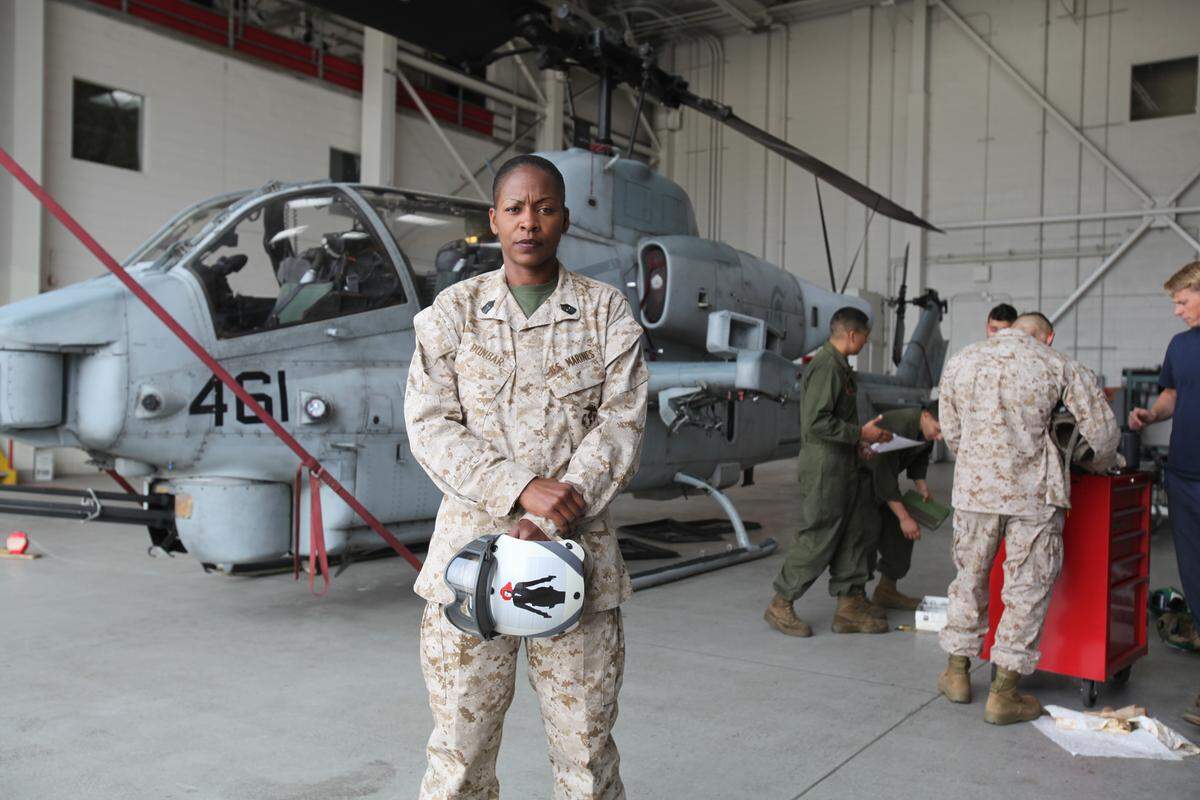Sgt. Maj. Donna Dunbar of Marine Light Attack Helicopter Training Squadron 303, stands in front of an AH-1W “Super Cobra” inside a hangar aboard Marine Corps Air Station Camp Pendleton, Calif., in 2013.