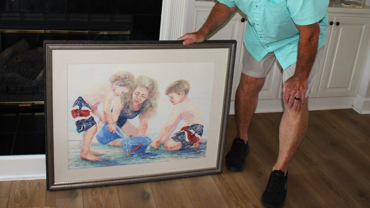 David Trapani holds up a drawing of his late wife Katie and their two sons Taylor and Reid, created by a local artist in 1996.