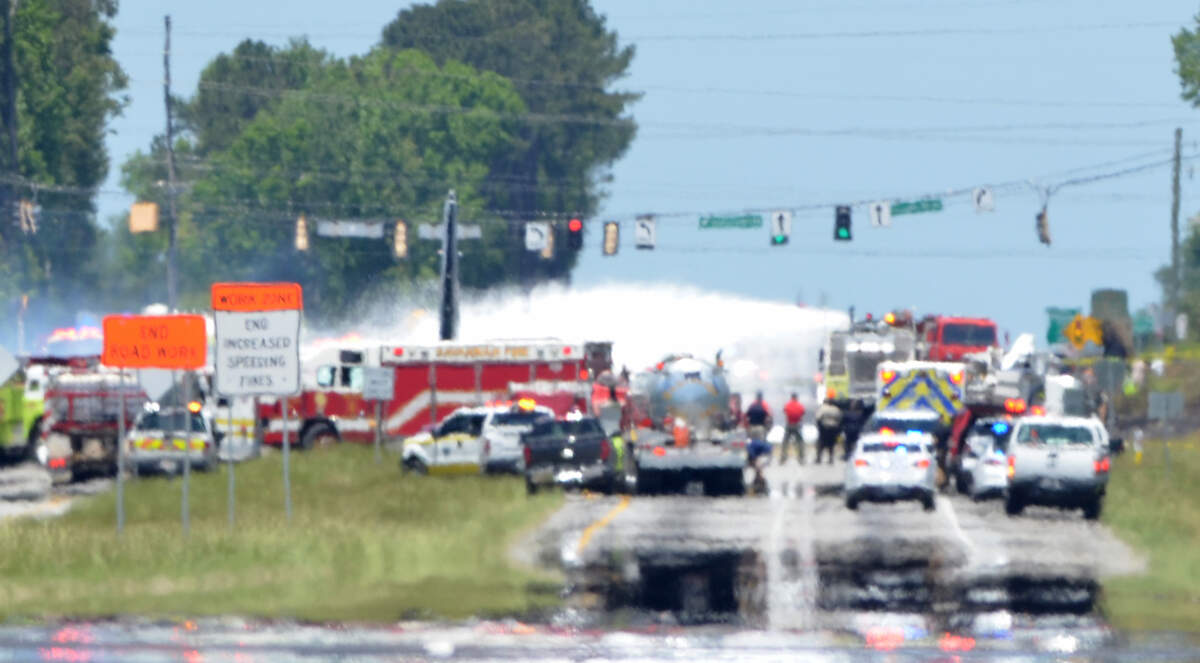 Firefighters hose down the scene of a C-130 cargo plane crash on Ga. 21 near Savannah-Hilton Head International Airport. The plane went down on the road near its intersection with Crossgate Road.