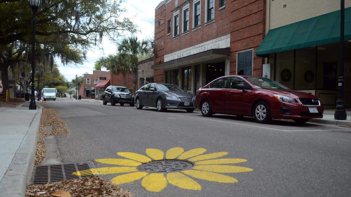 One of the five manholes that were painted by an unknown artist to look like a sunflower along Port Republic Street in Downtown Beaufort as seen on Monday afternoon.