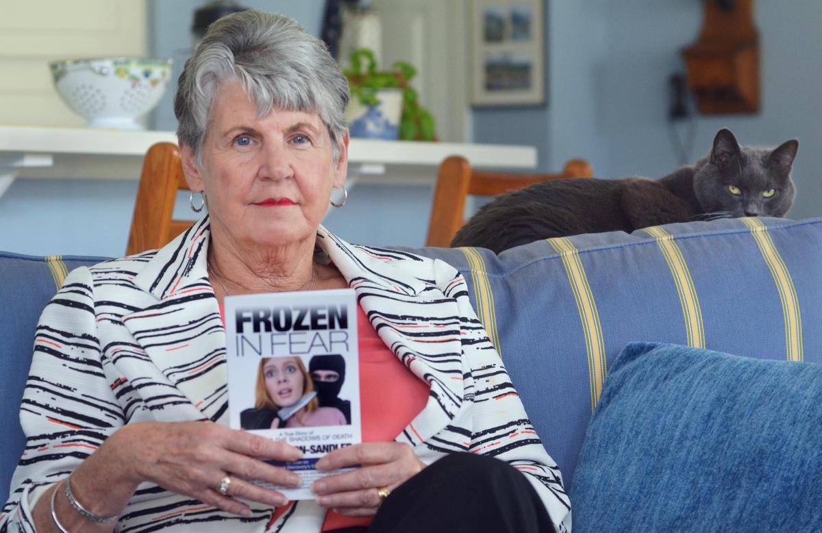 Rape survivor Jane Carson-Sandler, of Sun City, is photographed on March 1 holding a copy of her book about the experience called, “Frozen in Fear.” Carson-Sandler was one of may victims of a California serial rapist -- who has never been caught -- known as the East Area Rapist or the Golden State Killer.