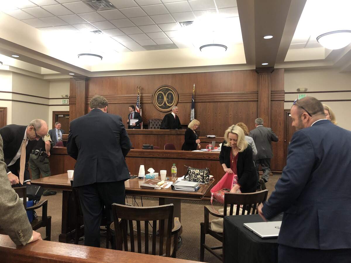 From left, attorneys Trenholm Walker and John Linton pack up with their client Kim Likins after she dropped her defamation claims against outspoken government critic Skip Hoagland on March 9, 2020.