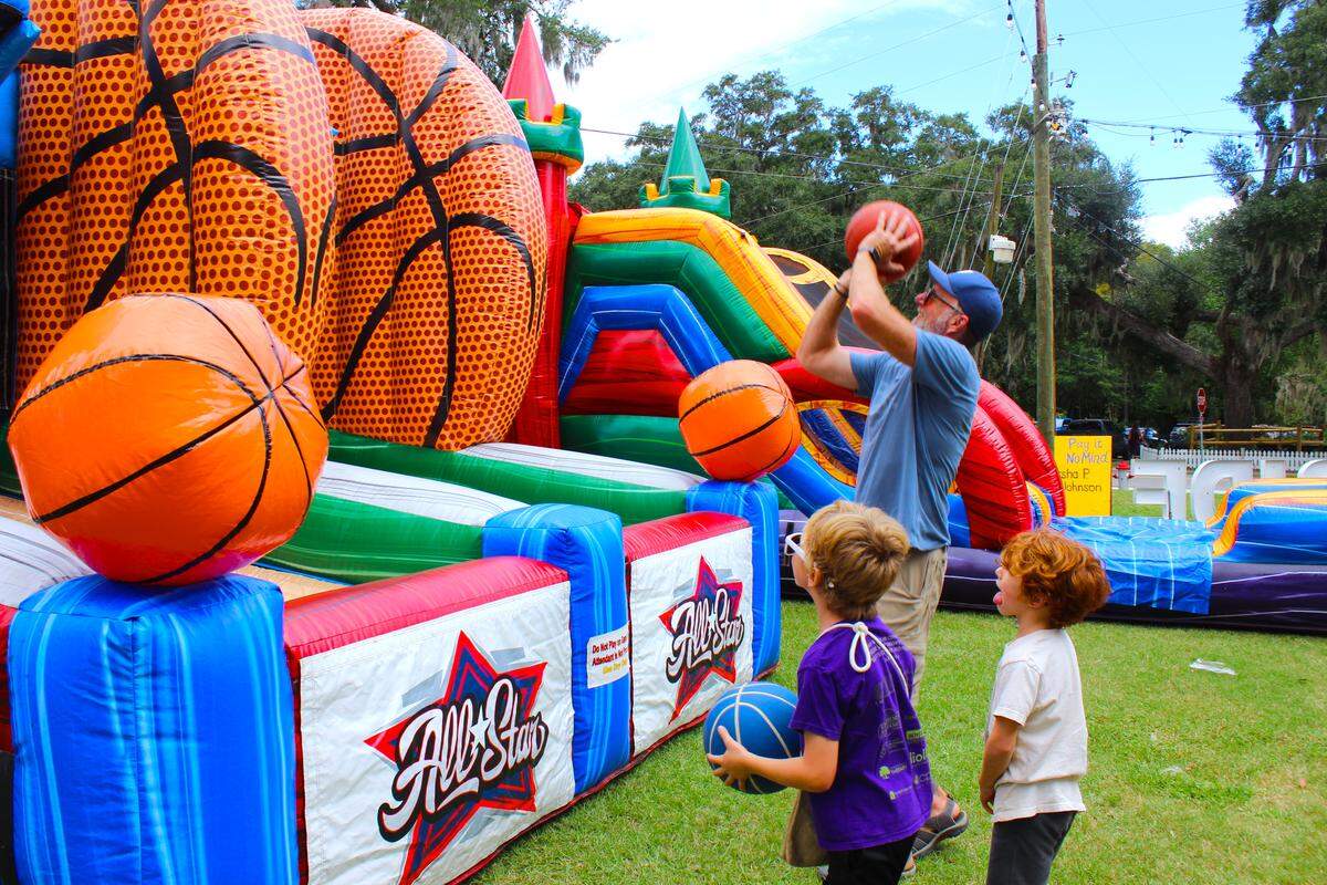 Chad Rentz, who teaches at Lowcountry Montessori, shoots hoops with his sons Sebastian and Julian. His wife, Tanya (not pictured), said they came to event to show their support for the LGBTQ community and “show out kids an environment where people are loved.”