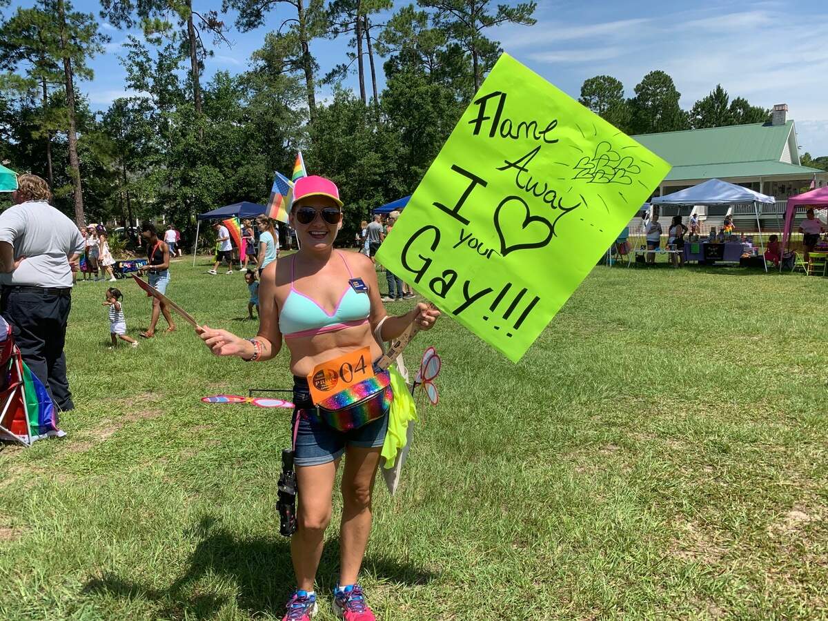 Calea Rush of Beaufort posing with one side of her sign. The other side says, “No matter what they say, it’s OK to be gay!”