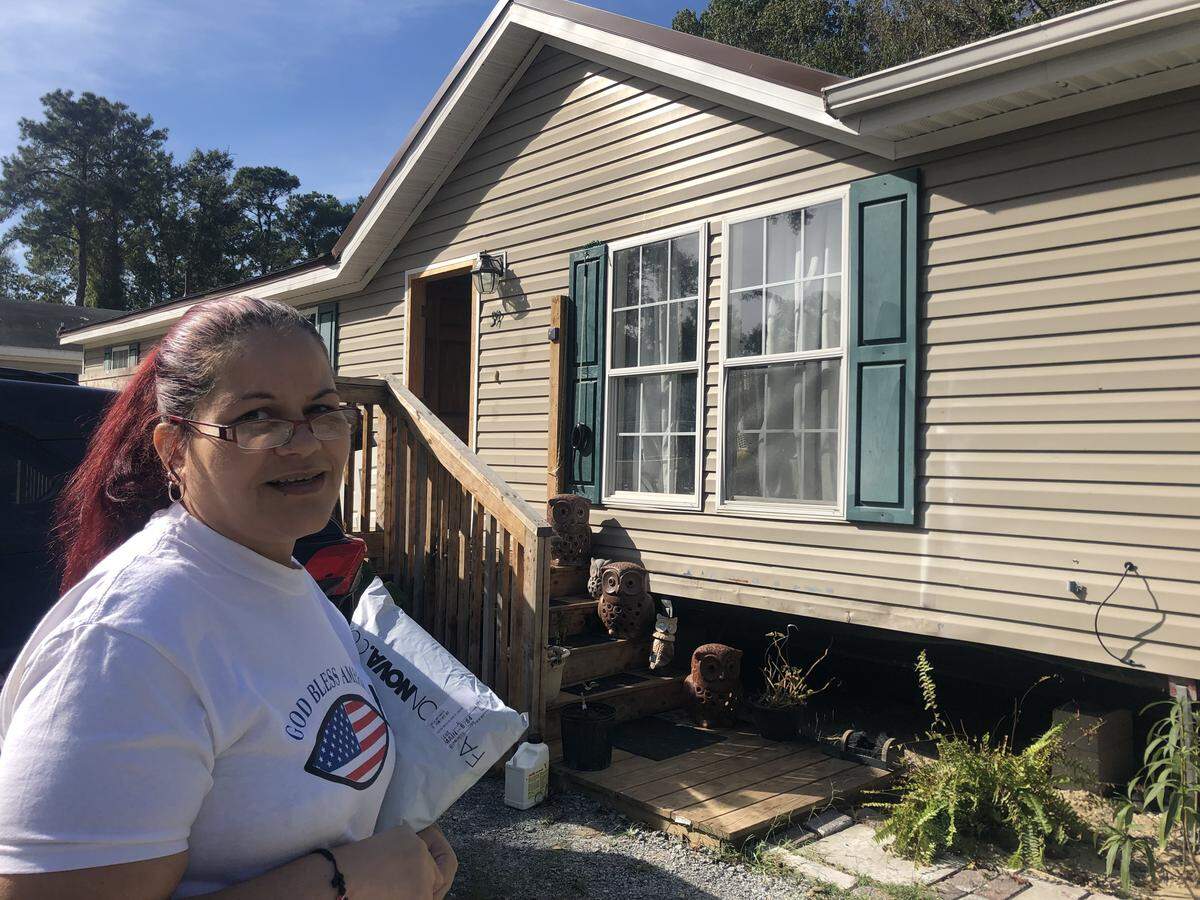 Jeannette Galvez-Martinez stands in front of her home in its new location on Gum Tree Road. It cost around $12,000 to move her trailer from Spanish Grove Trailer Park.