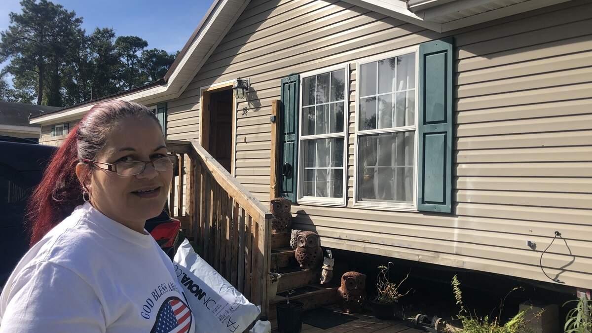 Jeannette Galvez-Martinez stands in front of her mobile home in South Carolina. It cost around $12,000 to move it from one park to another.