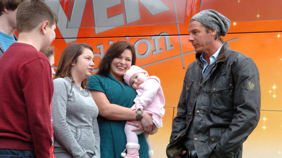 Ty Pennington, right, host of ABC's "Extreme Makeover: Home Edition," talks with members of the Dickinson family just after the the family learned it had been selected for the home makeover program.  