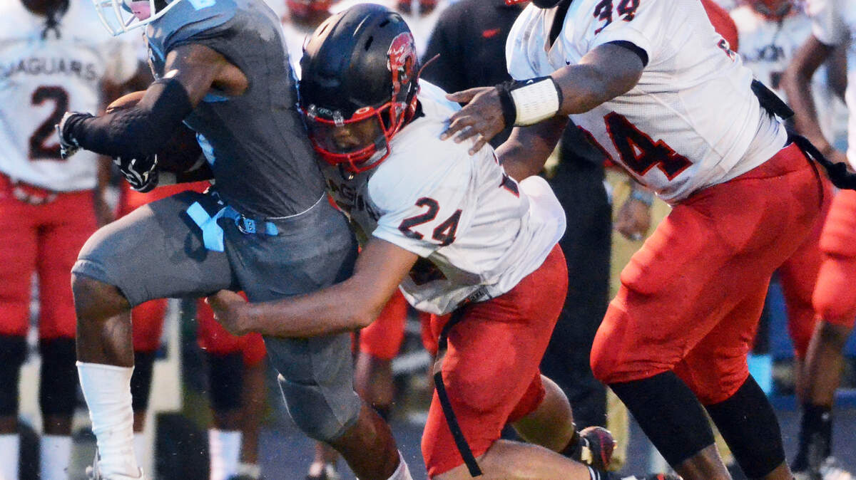 Hilton Head's Jestin Morrow gains some hard yardage with Jaguars Darius Solomon (24) and Jataree Williams in hot pursuit during Friday's season opener at Hilton Head Island High School.