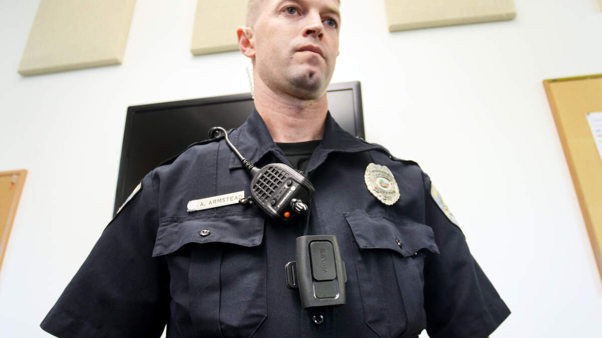 FILE: Bluffton police officer Doug Armstead shows off his body camera in the center of his chest below his radio microphone.