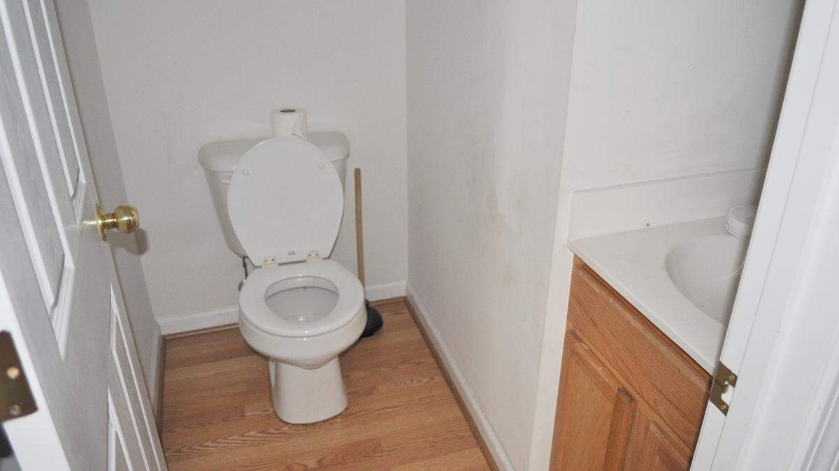 BEFORE: Bland laminate flooring, white walls and a cabinet vanity didn't make for an appealing powder room.
