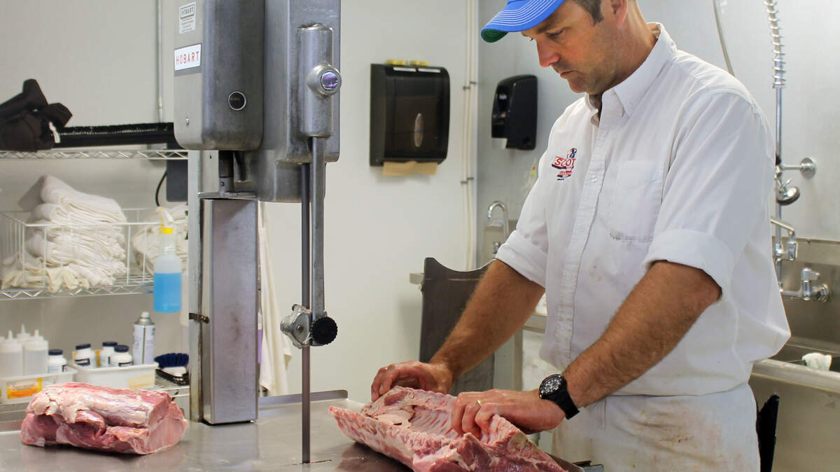 Adam Simoneaux, owner operato of Scotts Market in Bluffton, prepares to make special, made-to-order cuts at his butcher shop on June 25, 2015.