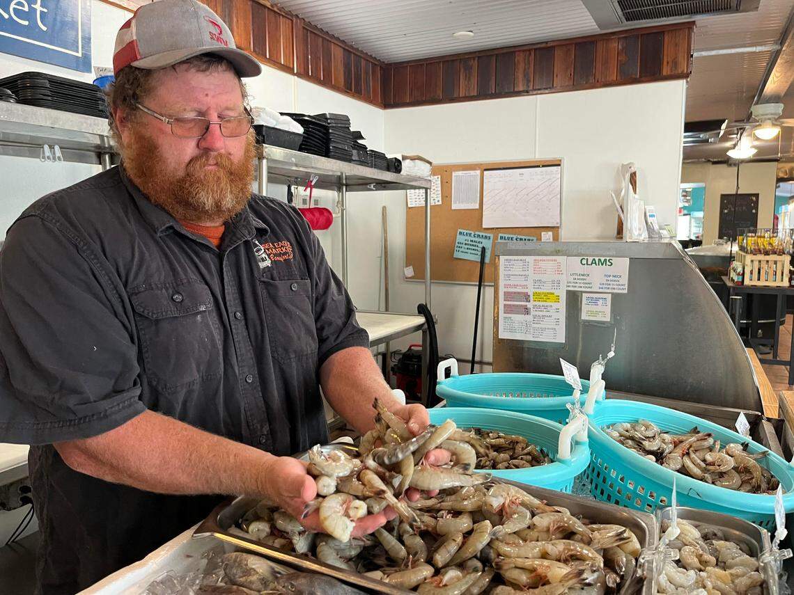 Craig Reaves, owner of Sea Eagle Market, shows off locally-caught shrimp at the Sea Eagle Market in Beaufort. 