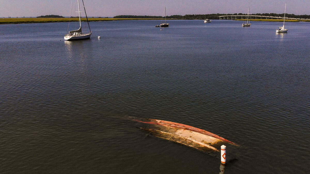 An abandoned, sunken boat is seen at low tide on Wed., Sept. 21, 2022 in Battery Creek with buoy markers to alert boaters near the shrimp dock in the Town of Port Royal.