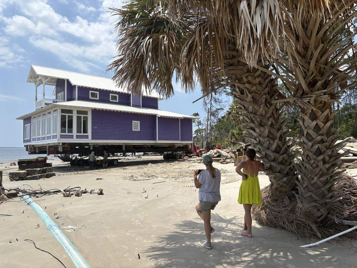 Debby and Katie Helmuth watch as worker move the “purple house” across the beach. The house used to belong to their good friend Susan Card before she sold it four years ago due to erosion issues. The new owner decided to move it off the beach to a new lot.