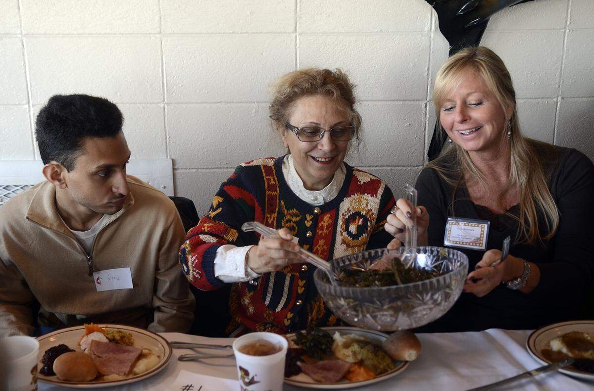 Maha Soliman, middle, of Hilton Head and Alma Colburn, right, of Cambridge, Md., help themselves to the collard greens as Soliman’s son, Greg, waits for his turn during the annual Community Thanksgiving Dinner at Hudson’s on Hilton Head Island.