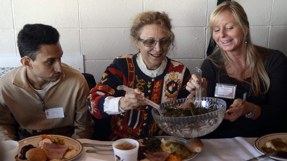 Maha Soliman, middle, of Hilton Head and Alma Colburn, right, of Cambridge, Md., help themselves to the collard greens as Soliman’s son, Greg, waits for his turn during the annual Community Thanksgiving Dinner at Hudson’s on Hilton Head Island.