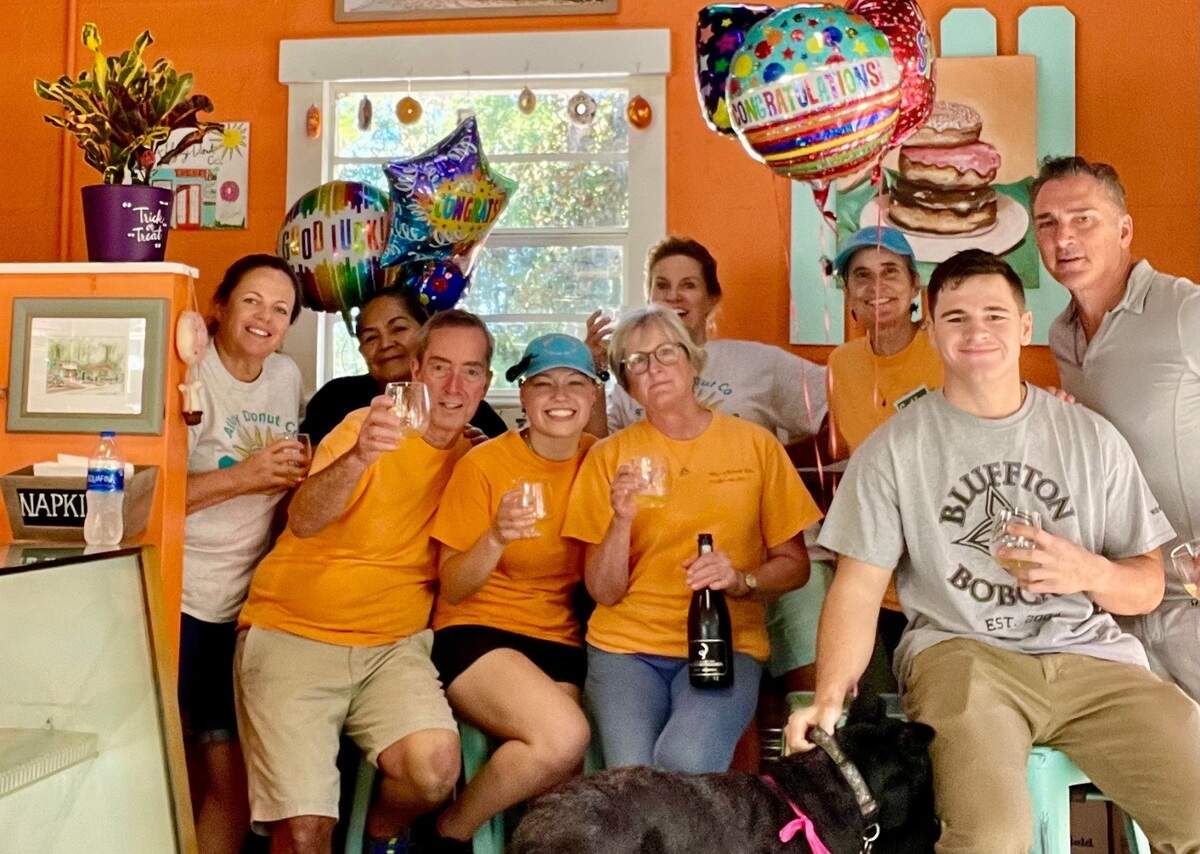 The staff at Alljoy Donut Co. offers a toast to former owners Bill and Donna Ellis (third and fifth from left) at the Bluffton shop.