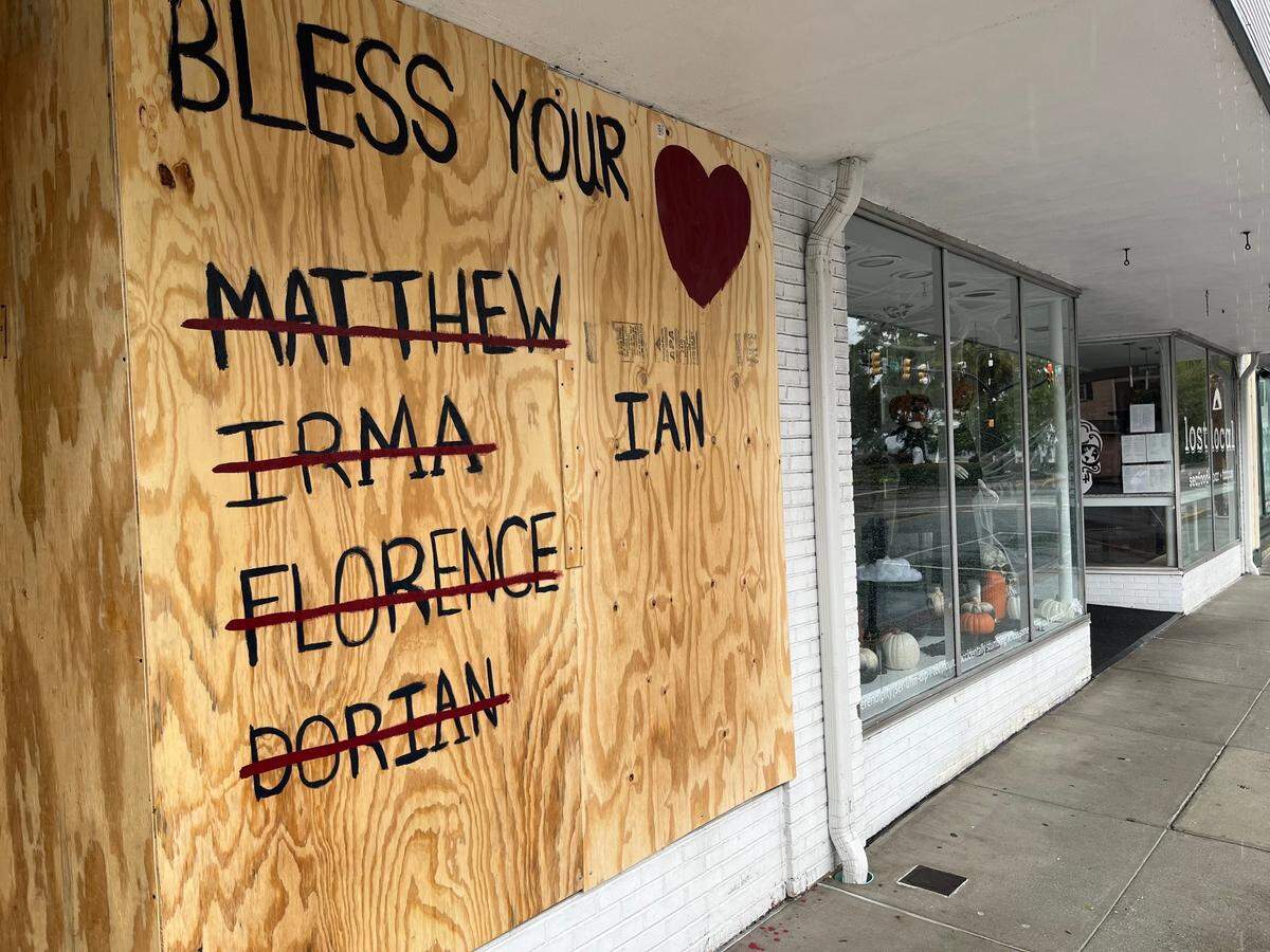 A board placed over the window of a shop on Bay Street in downtown Beaufort lists the names of previous hurricanes and the current one, Ian, as it approached the South Carolina coast on Friday morning, Sept. 30, 2022.
