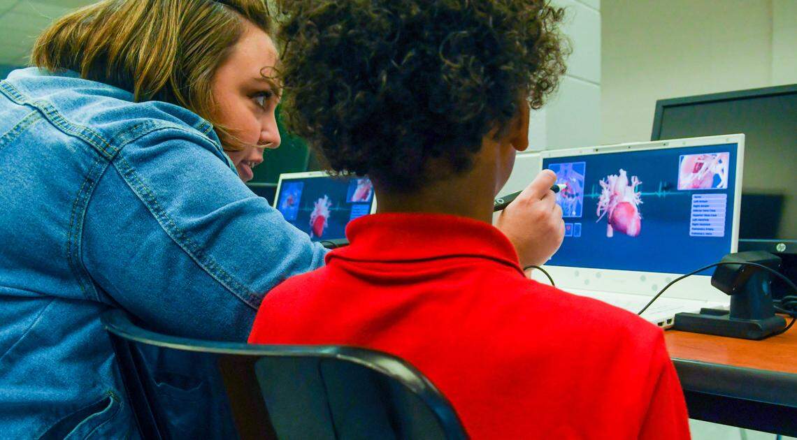 Third-grade teacher Amanda Dudas helps a student on Monday, Aug. 15, 2022, bring a 3-dimensional heart back to their screen while using a pencil-sized stylus on the first day of school at Mossy Oaks Elementary School.