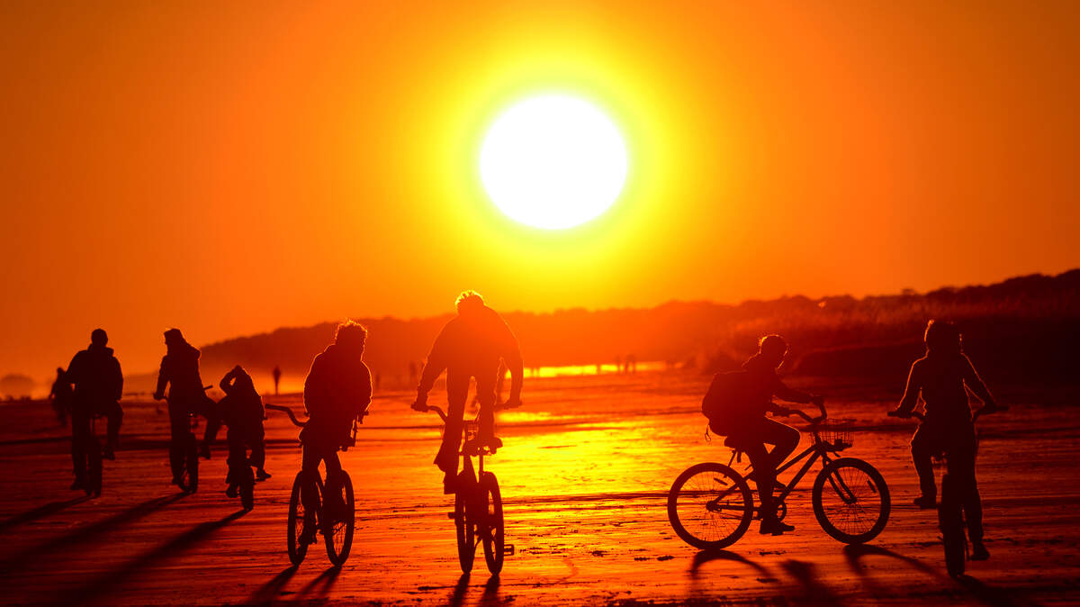 Beachgoers bicycle into the sunset on Hilton Head Island's North Forest Beach.