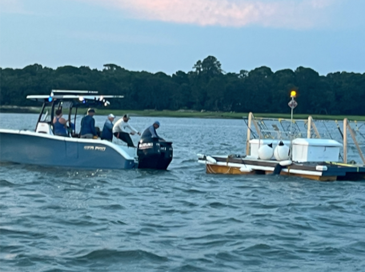 A biorock experimental floating platform is deployed in the Broad River near Eilliott’s Beach on Parris Island. It is part of an experiment to bring back marsh along the Broad River, which is disappearing. A turbine is located undeneath the platform. Eventually, electricity generated by the turbine spur growth of oysters on large concrete blocks in the water. The hope is that this “smart reef” will stop extreme erosional pressure along the southwest border of Parris Island.