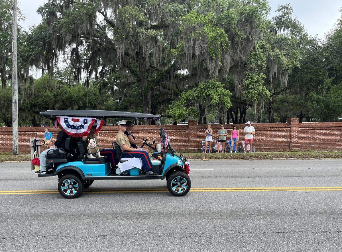 A golf cart is photographed cruising Boundary Street during a parade. Beaufort is one of several municipalities and neighborhoods to institute its own golf cart regulations in addition to state law.