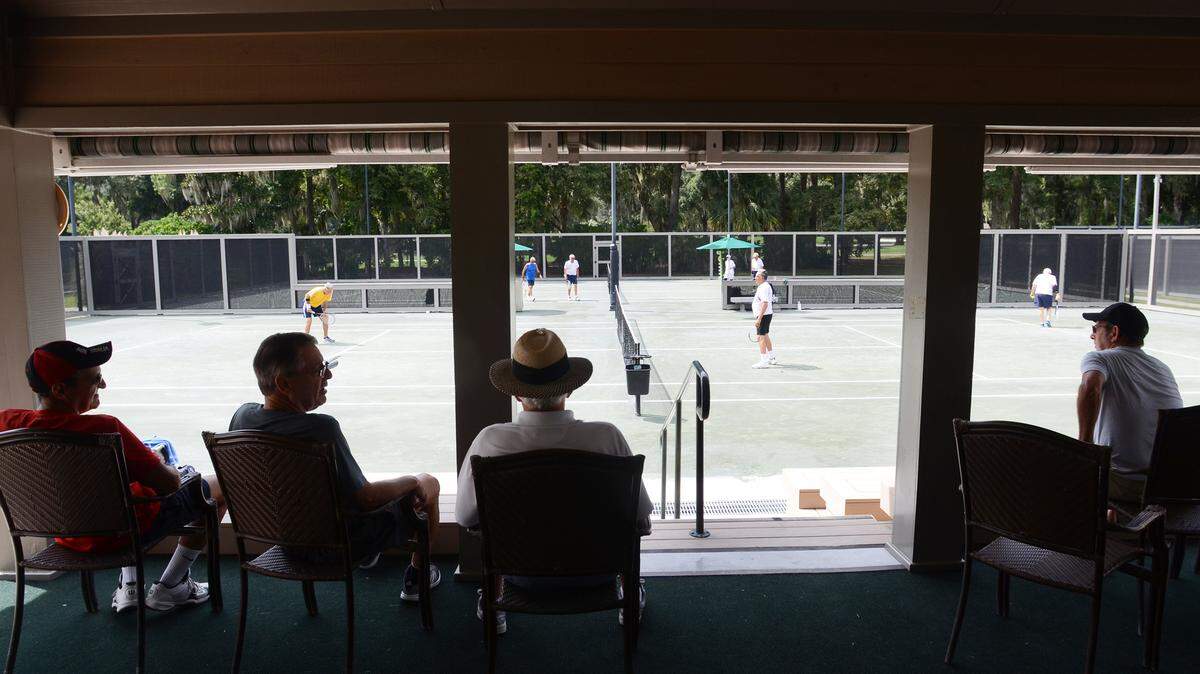 Members watch the action on the court from the comfort of a new covered spectator area at the Moss Creek Tennis Center on Wednesday. The center has undergone an extensive renovation over the summer. Improvements include a new clubhouse with observation deck, increased office space, storage space and a kitchen. The renovations led to Moss Creek being one of six private clubs in the country selected to be the recipient of the United States Tennis Association's Outstanding Tennis Facility Award. Club members celebrated the improvements and the award on Wednesday with a grand opening cookout and professional exhibition.