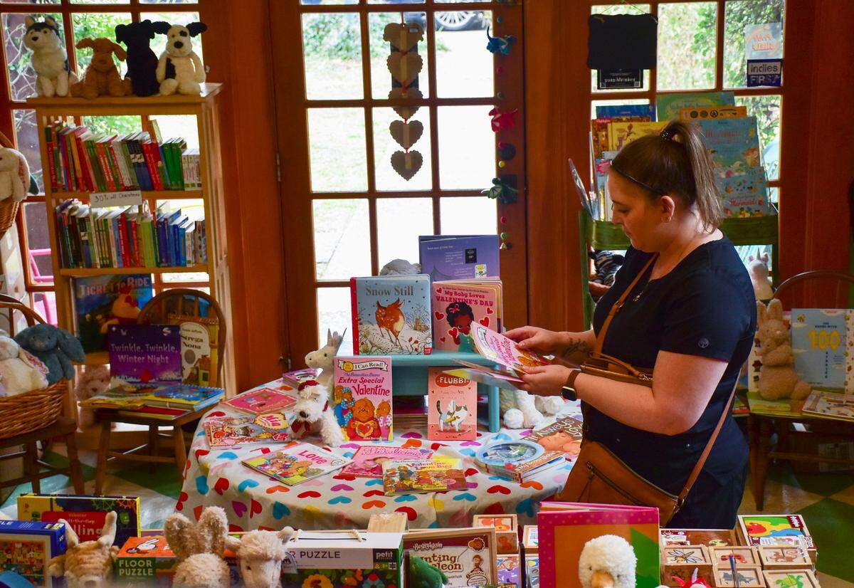 Laura Cilli, of Bluffton, selects books for her child at the Storybook Shoppe in Old Town Bluffton, which is seeking a new location. Owner Sally Sue Lavinge says the building owner gave notice on Jan. 5, 2024 that the store has 30 days to vacate, after 15-years as a month-to-month tenant.