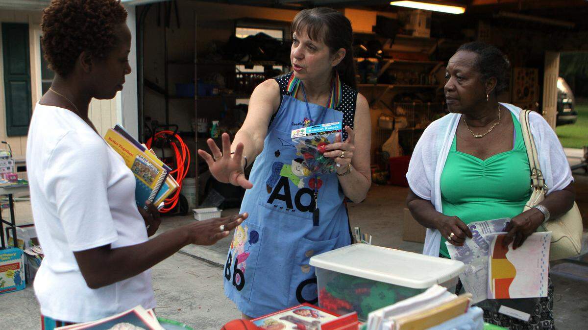Barb Hodgins, center, explains to Tara Morris, left, and her mother Ernestine Morris how to use one of the teaching tools that she had for sale during the garage sale at her home on Saturday morning in Bluffton.  Hodgins, a veteran teacher, sold new and used elementary school teaching materials during the sale with proceeds going to help the family of Josh Aragon, the son of two Beaufort County School District teachers who has multiple sclerosis.