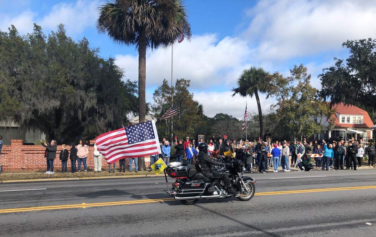 A motorcyclist who was among the escorts for the Wreaths for America trucks heading to Beaufort National Cemetery flies an American flag.