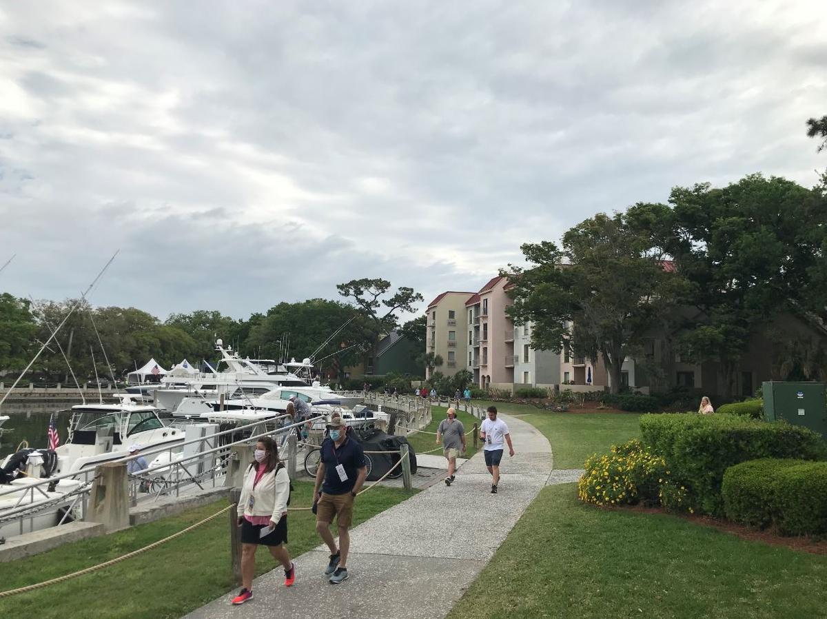 Golf fans walk from the Harbour Town Yacht Basin toward the Harbour Town Golf Links on Sunday, April 18, 2021.