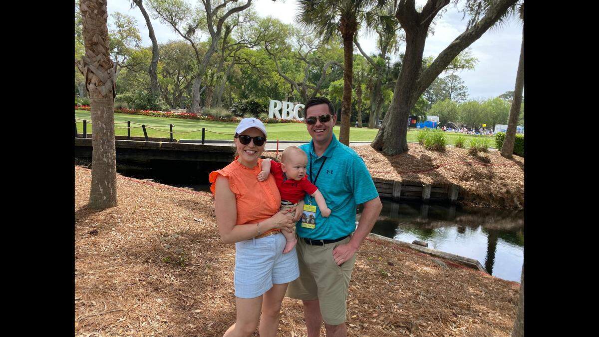 Christina Andrews (left) and her husband, Michael Andrews (right), attend their first golf tournament as parents of 10-month-old Jacob (center) on Thursday, April 14, 2022. “Sharing this experience with his son is the biggest thing for us. He grew up with his dad coming [to the Heritage] so the tradition lives on,” said Christina Andrews.
