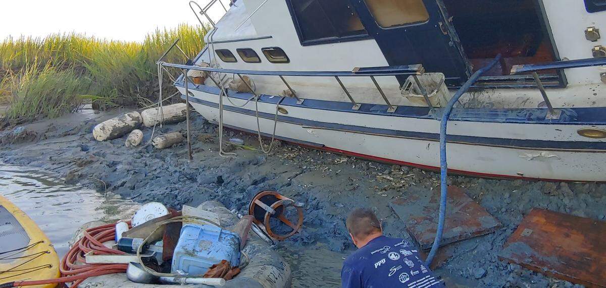Eric Bollinger attempts to right his boat, The Tiki Hut, near Calibogue Sound off Hilton Head Island.