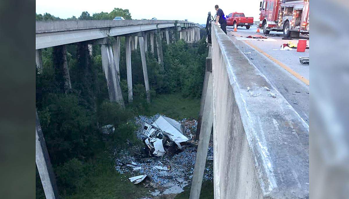Firefighters from the Hardeeville Professional Firefighters Association survey crash damage underneath an overpass on I-95 near the South Carolina state line Tuesday morning after a semi truck ran off the road and over the side of the overpass. The driver survived the fall with only “minor injuries.”
