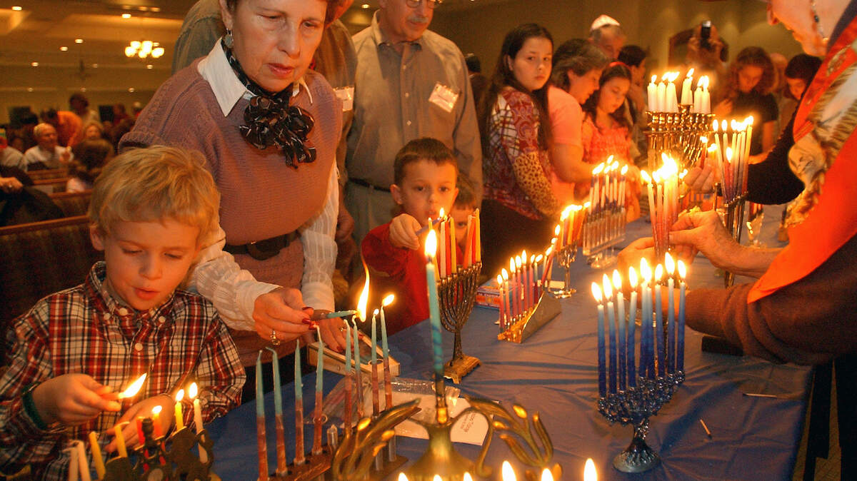 FILE: Dillon Snelgrove, 4, and Ruth Levy, left, light their family menorahs during the Night of 100 Menorahs at the Sanctuary at Beth Yam Synagogue on Hilton Head Island. The service marked the eighth night of Hanukkah and the seventh year since the previous Rabbi Mark Covitz started the tradition of members bringing their menorahs together in 2002. "It's fun and enjoyable to light them all together in celebration," member Judy Bluestone said.
