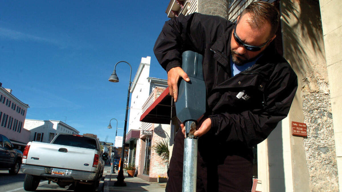 In this file photo from January 2011, James Holt, with Park Beaufort, is pictured re-installing a coin-operated parking meter on Bay Street in downtown Beaufort after the city's seven-month failure of pay stations that accepted credit cards.