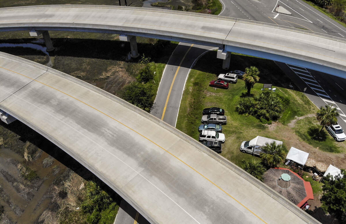 This photo taken with a drone on Monday shows a number of vehicles parked under the Bluffton Parkway Flyover at Fording Island Road Extension. Several of the cars had what resembled parking permits displayed on their dashboard that noted vehicles were owned by workers of the fruit stand, property owners on Daufuskie Island or were utilizing the Daufuskie Island Ferry service. According to a spokesperson with the S.C. Department of Transportation, the vehicles are parked illegally on state property and that the permits issued are not legal.
